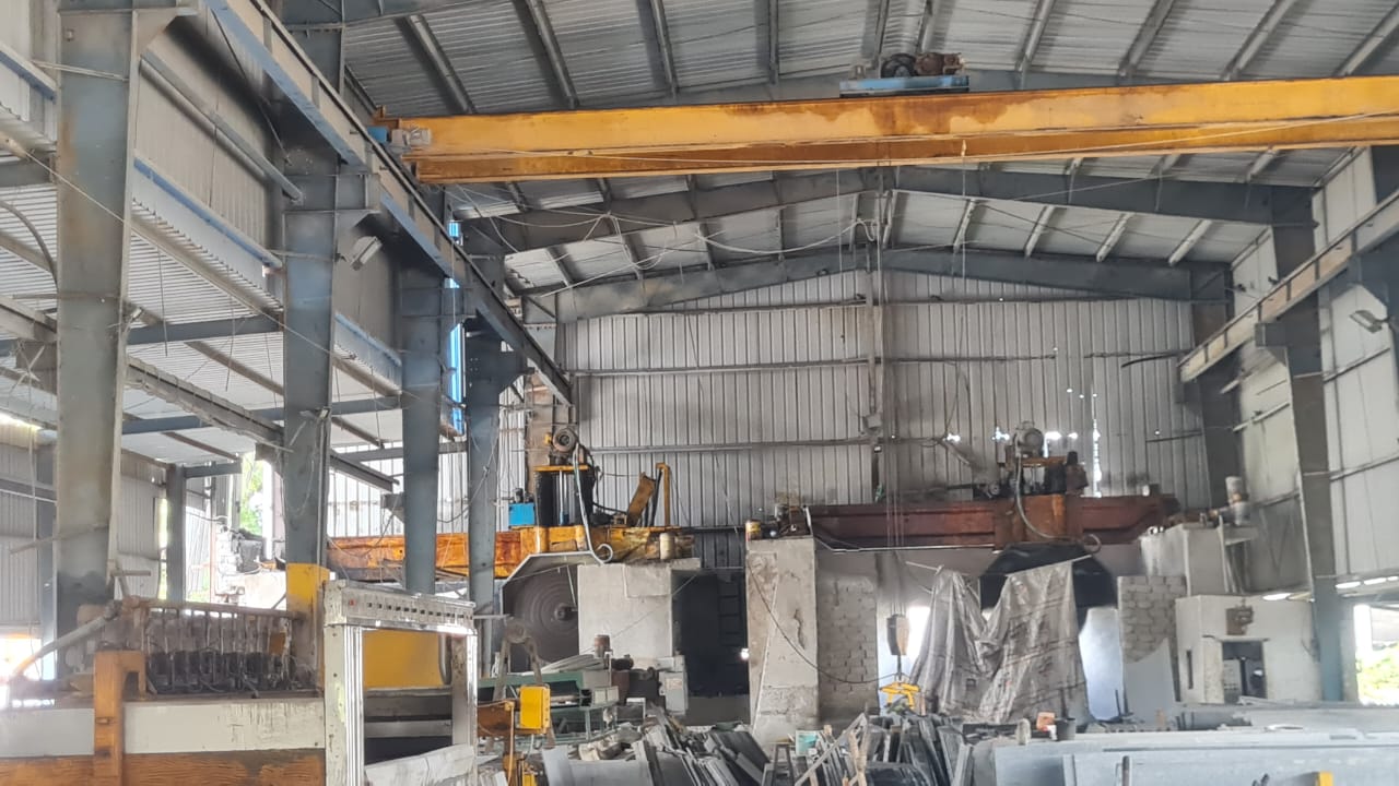 Cutting shed interior with a yellow overhead crane and block cutters